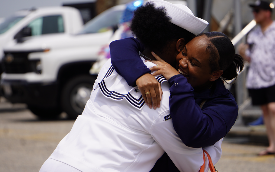 A sailor hugs a woman.